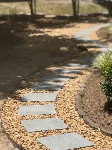 Curved stone path with gravel and landscaped lawn care design