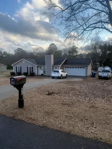Bare winter lawn needs care, suburban house with cars in driveway